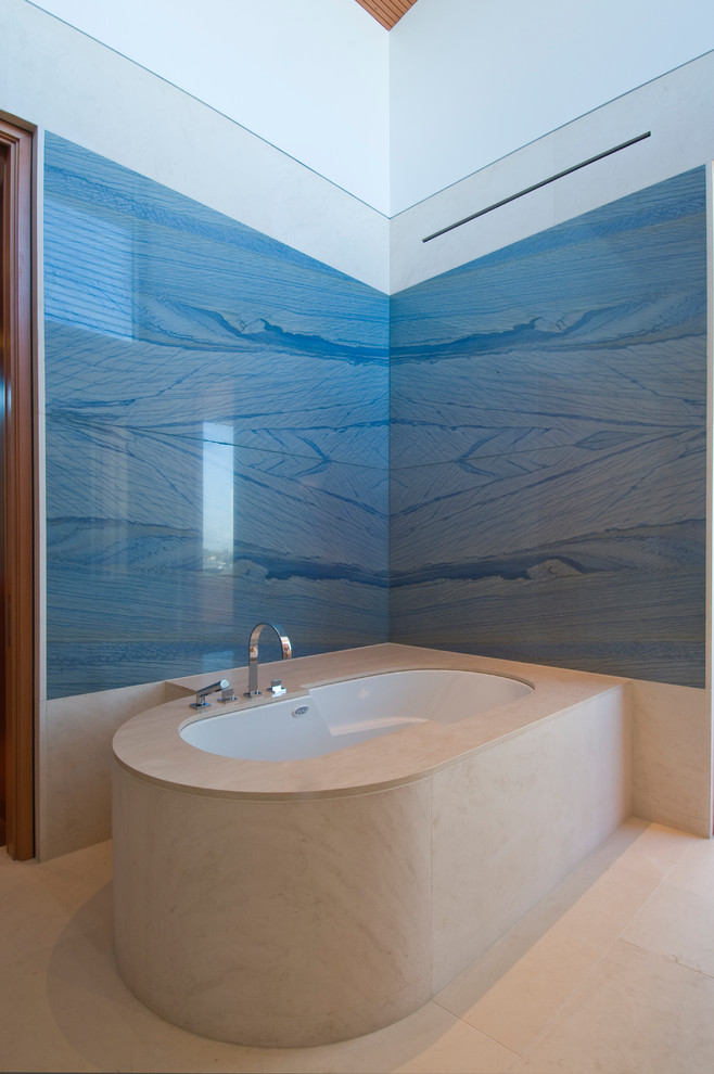 Foto di una stanza da bagno padronale design con vasca freestanding, piastrelle blu, pareti blu, pavimento in pietra calcarea e pavimento bianco