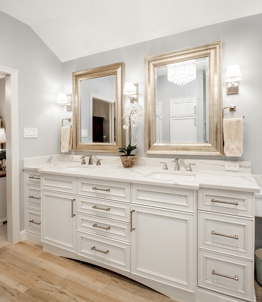 Inspiration for a medium sized traditional ensuite bathroom in Dallas with recessed-panel cabinets, white cabinets, a corner shower, a two-piece toilet, grey tiles, marble tiles, grey walls, porcelain flooring, a submerged sink, engineered stone worktops, brown floors, a hinged door and white worktops.