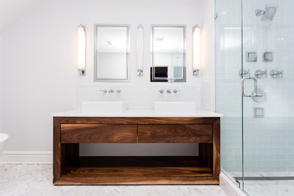 Réalisation d'une salle de bain principale design en bois brun avec un placard sans porte, une baignoire indépendante, un carrelage blanc, un carrelage métro, un mur gris, un sol en carrelage de terre cuite, une vasque et un plan de toilette en marbre.