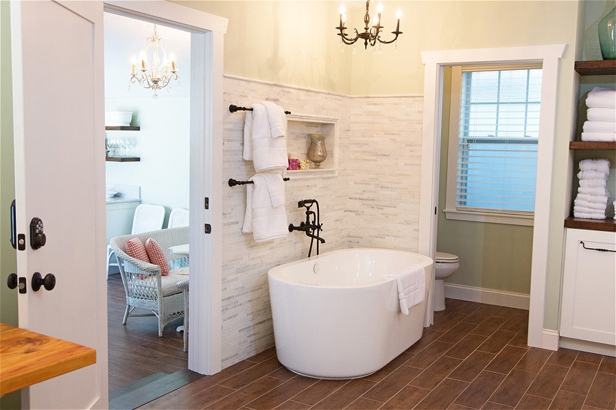 Modelo de cuarto de baño principal marinero de tamaño medio con bañera exenta, paredes blancas, suelo de baldosas de cerámica y suelo marrón