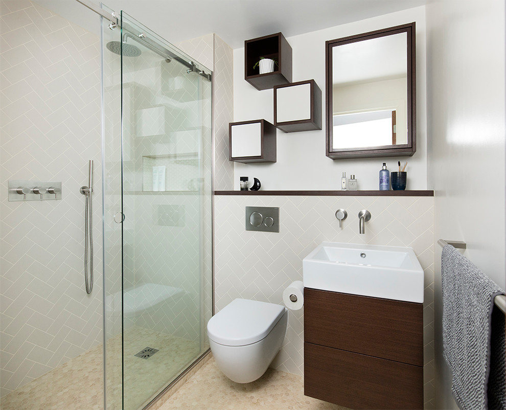 This is an example of a small retro bathroom in London with brown cabinets, a wall mounted toilet, beige tiles, porcelain tiles, a wall-mounted sink, a sliding door, beige floors, flat-panel cabinets and white walls.