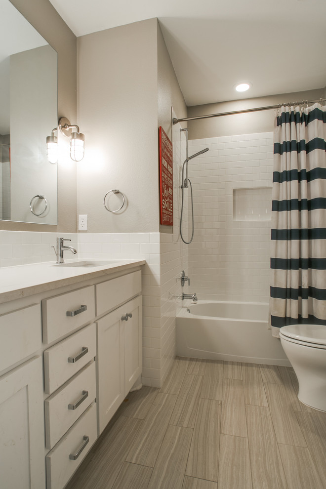 Idéer för ett mellanstort klassiskt badrum, med ett undermonterad handfat, skåp i shakerstil, vita skåp, marmorbänkskiva, ett badkar i en alkov, en dusch/badkar-kombination, vit kakel, keramikplattor, beige väggar och klinkergolv i keramik