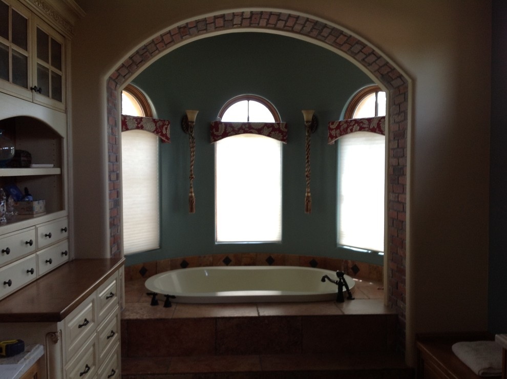На фото: главная ванная комната среднего размера в стиле фьюжн с фасадами с выступающей филенкой, белыми фасадами, накладной ванной и бежевыми стенами
