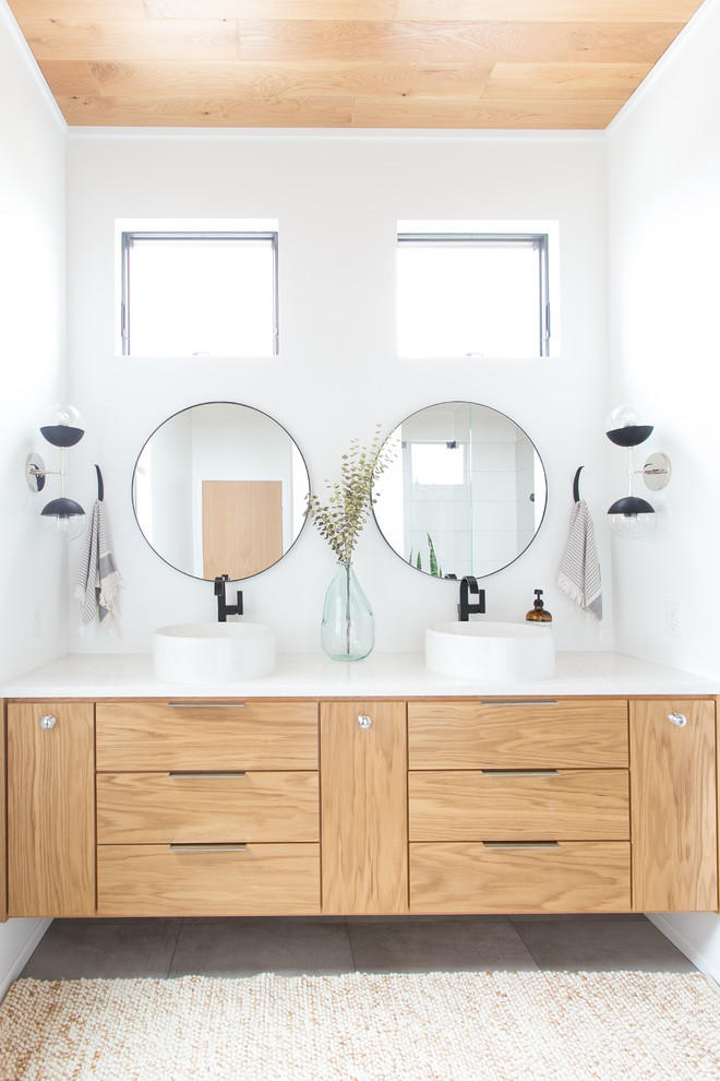 Idee per una stanza da bagno padronale design di medie dimensioni con ante lisce, ante in legno chiaro, pareti bianche, lavabo a bacinella, top in superficie solida e top bianco