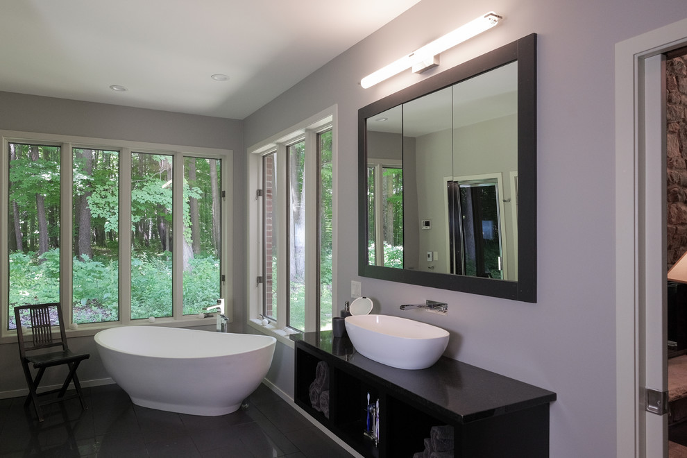 На фото: главная ванная комната среднего размера в стиле кантри с отдельно стоящей ванной с