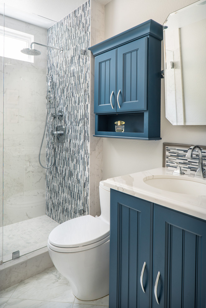 Diseño de cuarto de baño clásico de tamaño medio con armarios con paneles empotrados, puertas de armario azules, baldosas y/o azulejos multicolor, aseo y ducha y encimera de cuarzo compacto