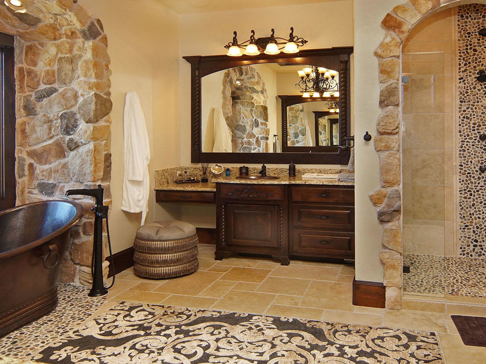 Foto på ett stort medelhavsstil en-suite badrum, med skåp i mörkt trä, ett fristående badkar, en dusch i en alkov, stenkakel, beige väggar, klinkergolv i keramik, granitbänkskiva, flerfärgad kakel, ett nedsänkt handfat och luckor med upphöjd panel