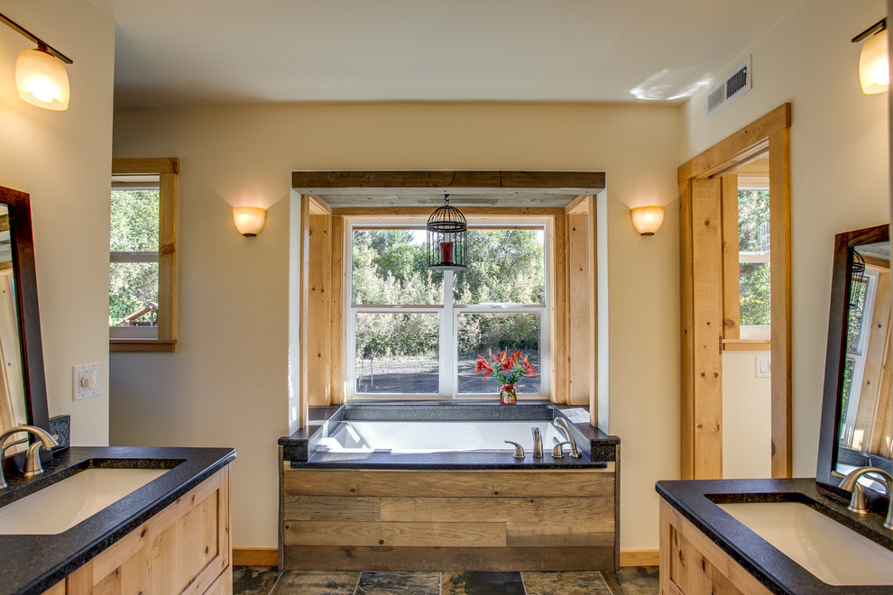 Mid-sized mountain style master multicolored tile and stone tile slate floor bathroom photo in Seattle with an undermount sink, shaker cabinets, light wood cabinets, granite countertops, a two-piece toilet and white walls