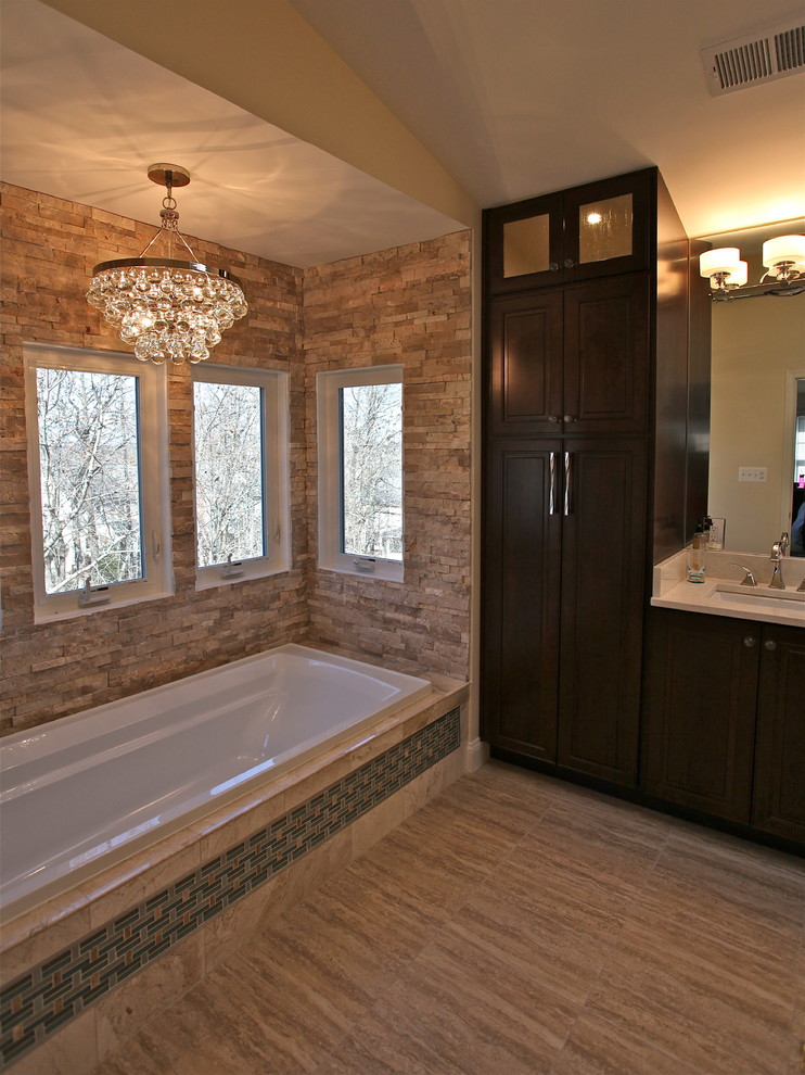 Mid-sized transitional master stone tile and brown tile porcelain tile bathroom photo in DC Metro with an undermount sink, raised-panel cabinets, dark wood cabinets, marble countertops, a two-piece toilet and beige walls