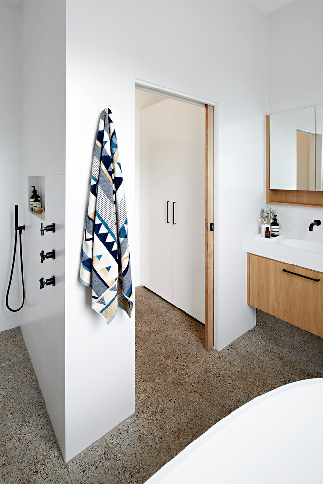 Inspiration for a medium sized contemporary shower room bathroom in Melbourne with light wood cabinets, a freestanding bath, a walk-in shower, a wall mounted toilet, white tiles, white walls, terrazzo flooring, a submerged sink, multi-coloured floors, an open shower, white worktops, freestanding cabinets, metro tiles and engineered stone worktops.