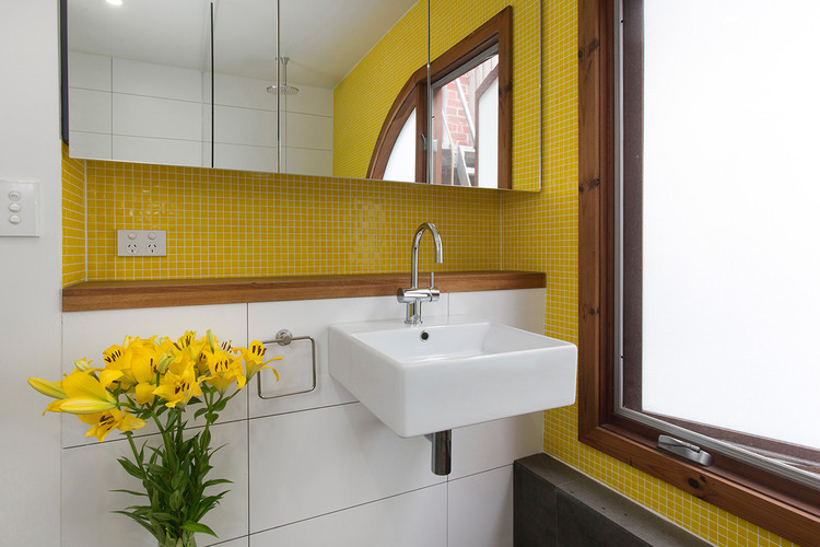 Aménagement d'une salle de bain contemporaine avec un lavabo suspendu et un carrelage jaune.