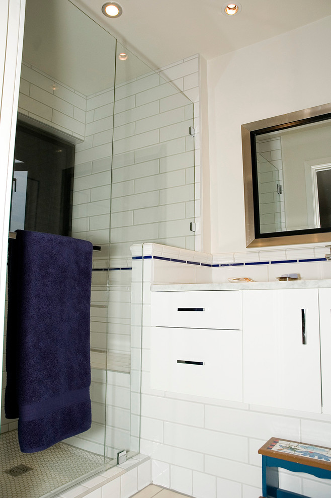 На фото: детская ванная комната среднего размера в современном стиле с врезной раковиной, стеклянными фасадами, белыми фасадами, мраморной столешницей, угловым душем, унитазом-моноблоком, белой плиткой, керамической плиткой, белыми стенами и полом из керамической плитки с