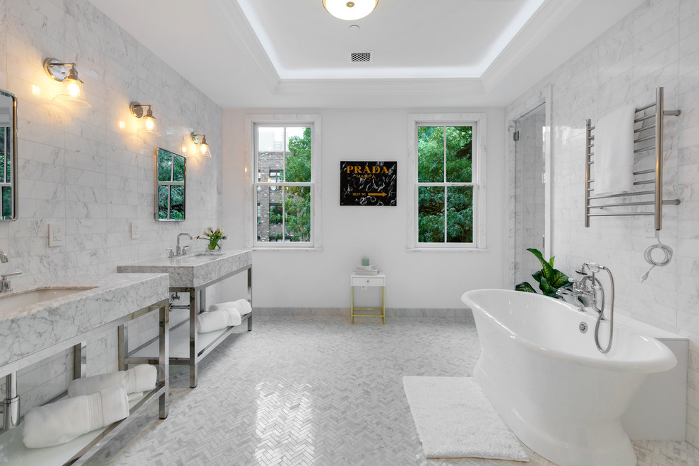 This is an example of a traditional ensuite bathroom in New York with a freestanding bath, marble tiles, white walls, marble flooring, marble worktops, white tiles, a submerged sink, white floors and white worktops.