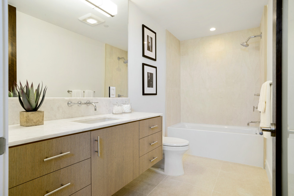 Свежая идея для дизайна: детская ванная комната среднего размера в современном стиле с плоскими фасадами, светлыми деревянными фасадами, душем над ванной, раздельным унитазом, серой плиткой, керамической плиткой, бежевыми стенами, полом из керамической плитки, врезной раковиной, мраморной столешницей, бежевым полом, шторкой для ванной, белой столешницей, сиденьем для душа, тумбой под одну раковину и подвесной тумбой - отличное фото интерьера