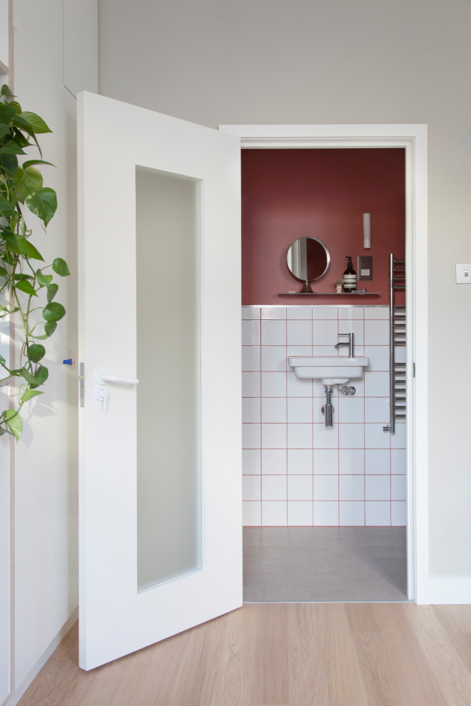 Cette image montre une petite salle de bain principale design avec un carrelage blanc, des carreaux de céramique, un mur rouge, un sol en carrelage de céramique, un lavabo suspendu et un sol gris.