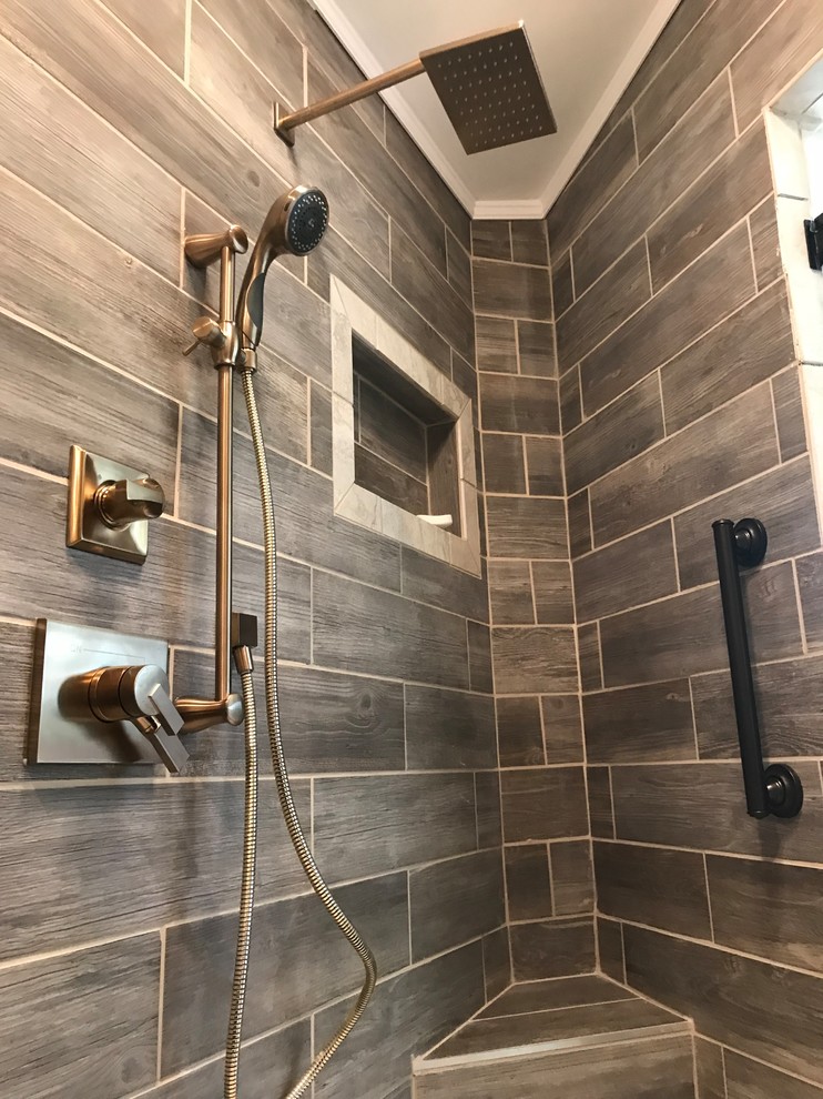 Small modern ensuite wet room bathroom in Other with a two-piece toilet, brown tiles, ceramic tiles, brown walls, ceramic flooring, a wall-mounted sink, beige floors and a hinged door.