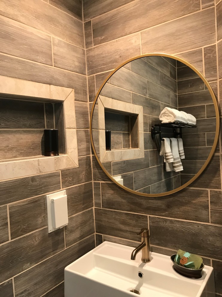 Bild på ett litet funkis en-suite badrum, med våtrum, en toalettstol med separat cisternkåpa, brun kakel, keramikplattor, bruna väggar, klinkergolv i keramik, ett väggmonterat handfat, beiget golv och dusch med gångjärnsdörr