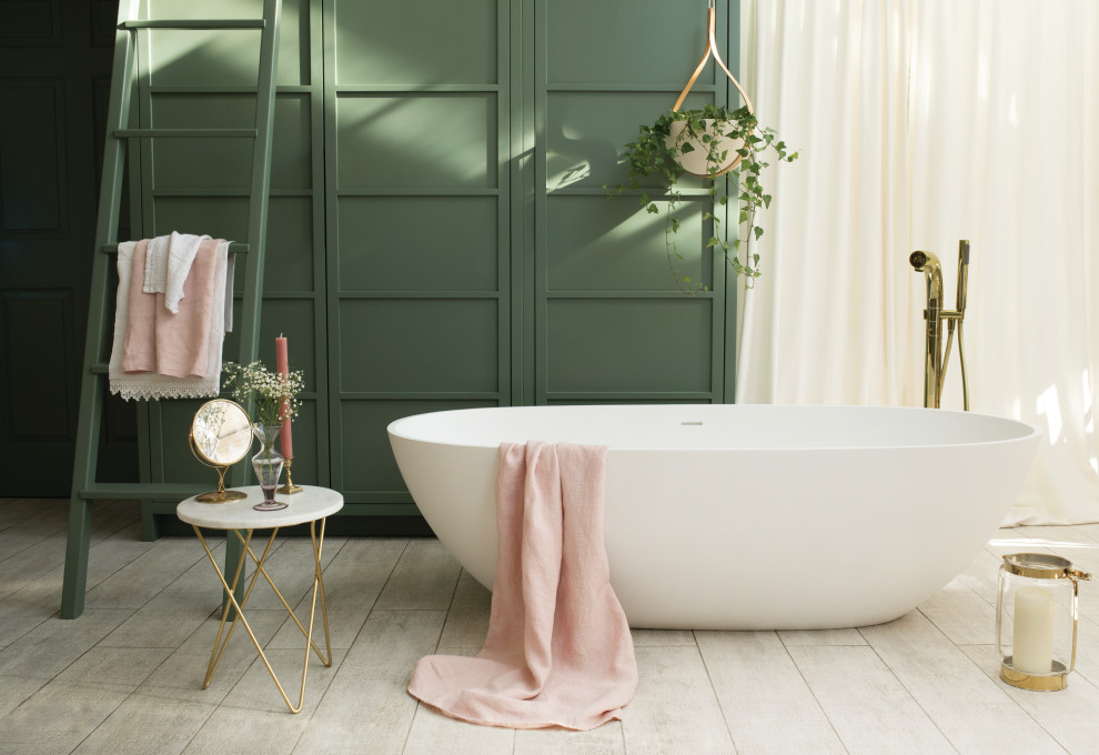 На фото: детская ванная комната среднего размера в современном стиле с отдельно стоящей ванной, зелеными стенами, деревянным полом и панелями на части стены
