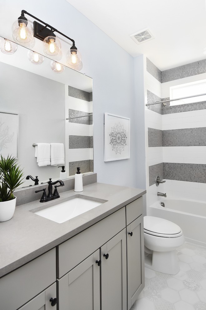 На фото: ванная комната в стиле неоклассика (современная классика) с серыми фасадами, душем над ванной, серой плиткой, разноцветной плиткой, белой плиткой, белым полом, фасадами в стиле шейкер, ванной в нише, врезной раковиной, серой столешницей и окном с