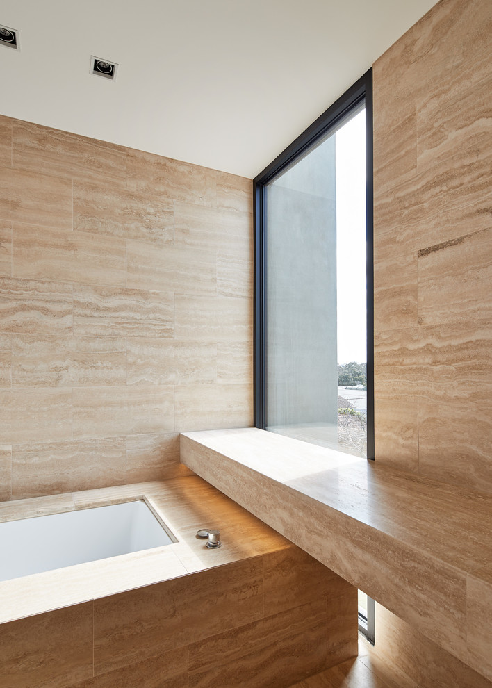 Immagine di una stanza da bagno padronale di medie dimensioni con vasca sottopiano, piastrelle beige, piastrelle in travertino, pavimento in travertino e pavimento beige