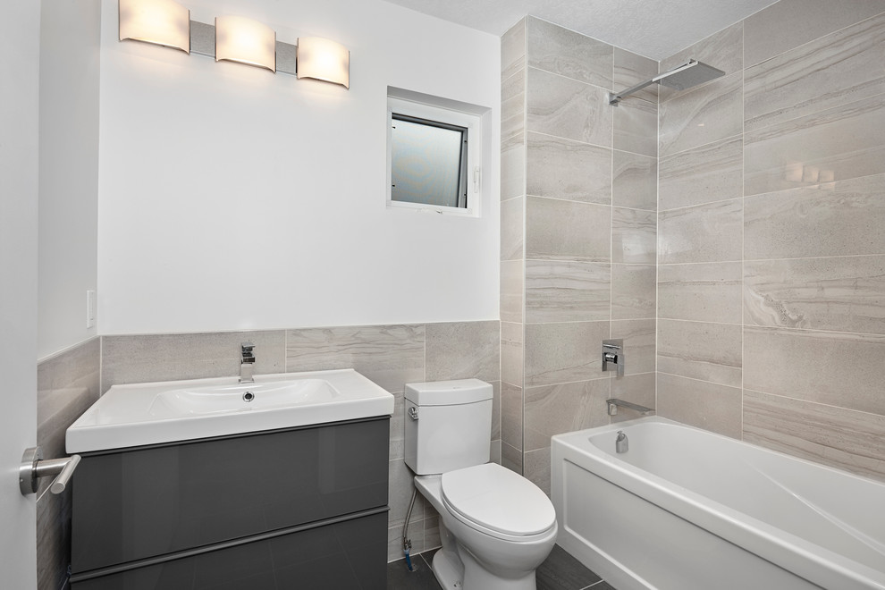 Inspiration för ett litet funkis badrum med dusch, med ett konsol handfat, släta luckor, grå skåp, grå kakel, porslinskakel, vita väggar, klinkergolv i porslin, ett badkar i en alkov och en toalettstol med separat cisternkåpa