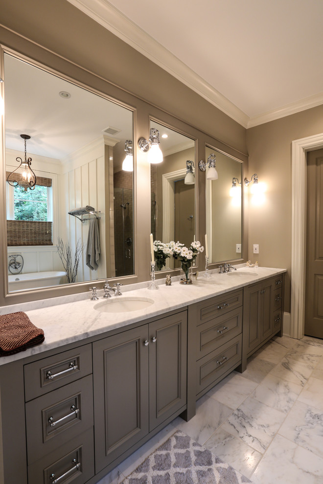 Example of a mid-sized transitional master white tile and stone tile marble floor bathroom design in Atlanta with an undermount sink, recessed-panel cabinets, brown cabinets, marble countertops, a one-piece toilet and brown walls