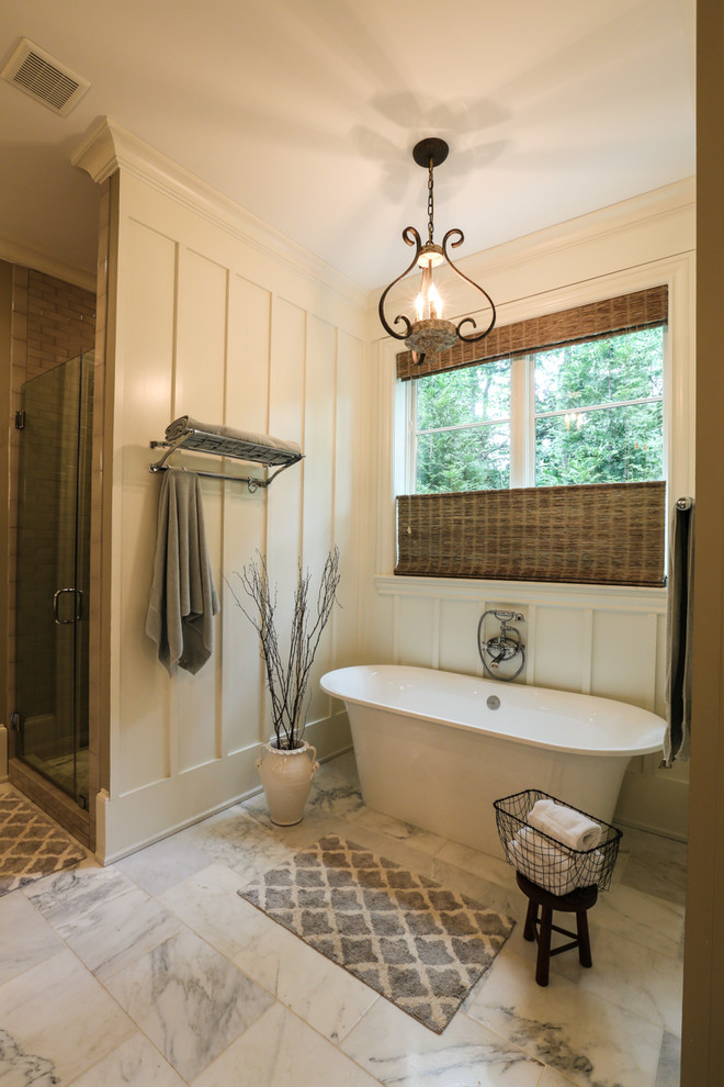 Стильный дизайн: главная ванная комната среднего размера в стиле неоклассика (современная классика) с фасадами с утопленной филенкой, коричневыми фасадами, мраморной столешницей, врезной раковиной, отдельно стоящей ванной, двойным душем, унитазом-моноблоком, белой плиткой, каменной плиткой, желтыми стенами и мраморным полом - последний тренд