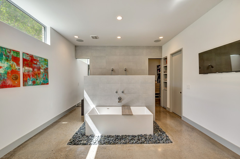 Diseño de cuarto de baño contemporáneo con bañera exenta, suelo de cemento y ducha abierta