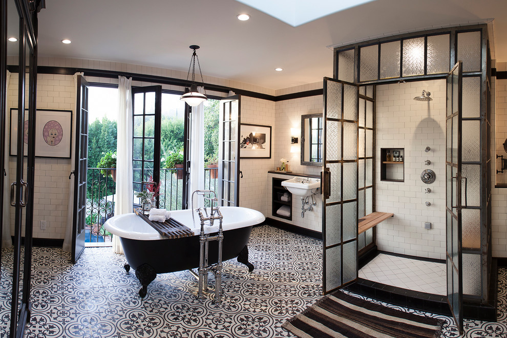На фото: ванная комната в стиле лофт с ванной на ножках, белыми стенами, полом из цементной плитки и разноцветным полом с