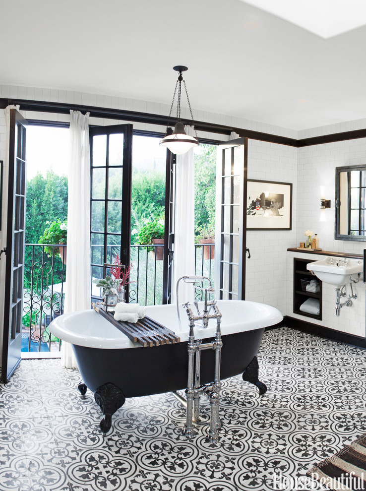 Exemple d'une salle de bain industrielle avec une baignoire sur pieds, un lavabo suspendu, un sol multicolore, un carrelage blanc, des carreaux de céramique, un mur blanc et carreaux de ciment au sol.