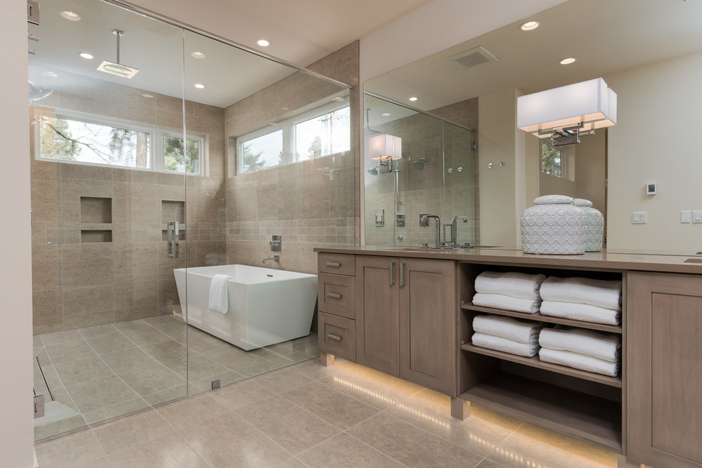 Design ideas for a large contemporary ensuite bathroom in Seattle with grey cabinets, a freestanding bath, a shower/bath combination, a one-piece toilet, beige tiles, stone tiles, grey walls, ceramic flooring, a submerged sink and granite worktops.