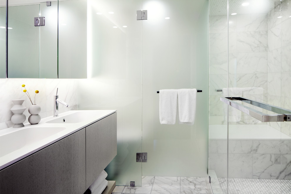 Idéer för att renovera ett litet funkis en-suite badrum, med ett integrerad handfat, släta luckor, grå skåp, bänkskiva i kvartsit, en dubbeldusch, en toalettstol med hel cisternkåpa, vit kakel, stenhäll, vita väggar och mosaikgolv