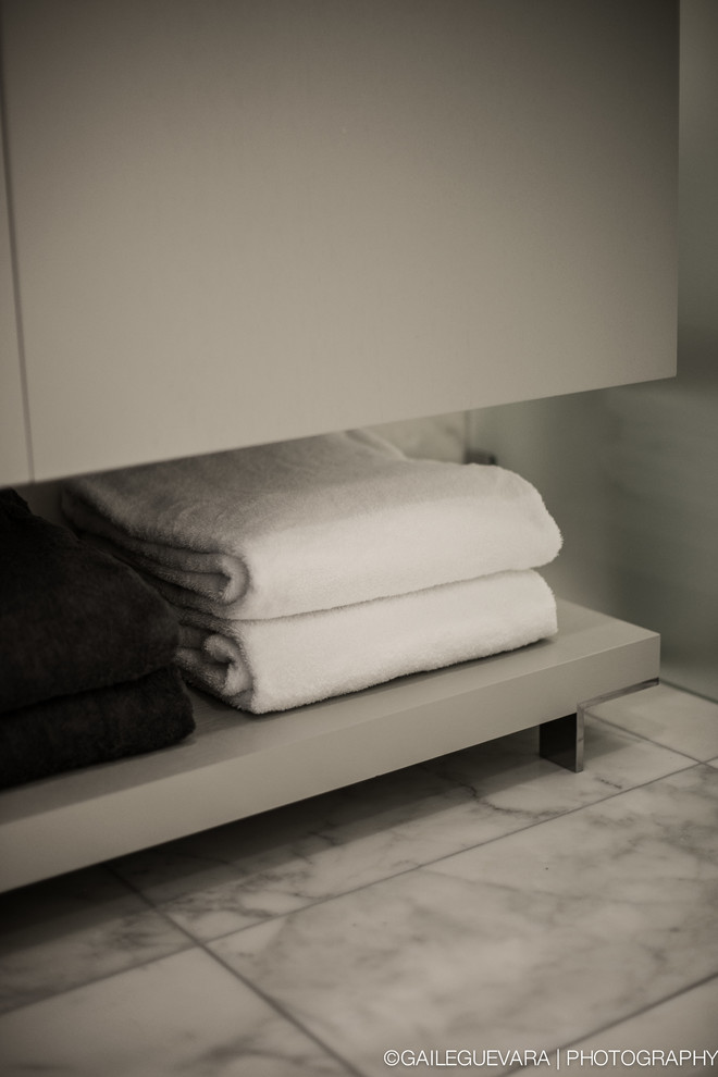 Modern inredning av ett litet en-suite badrum, med ett integrerad handfat, släta luckor, grå skåp, bänkskiva i kvartsit, en dubbeldusch, en toalettstol med hel cisternkåpa, vit kakel, stenkakel, vita väggar och mosaikgolv