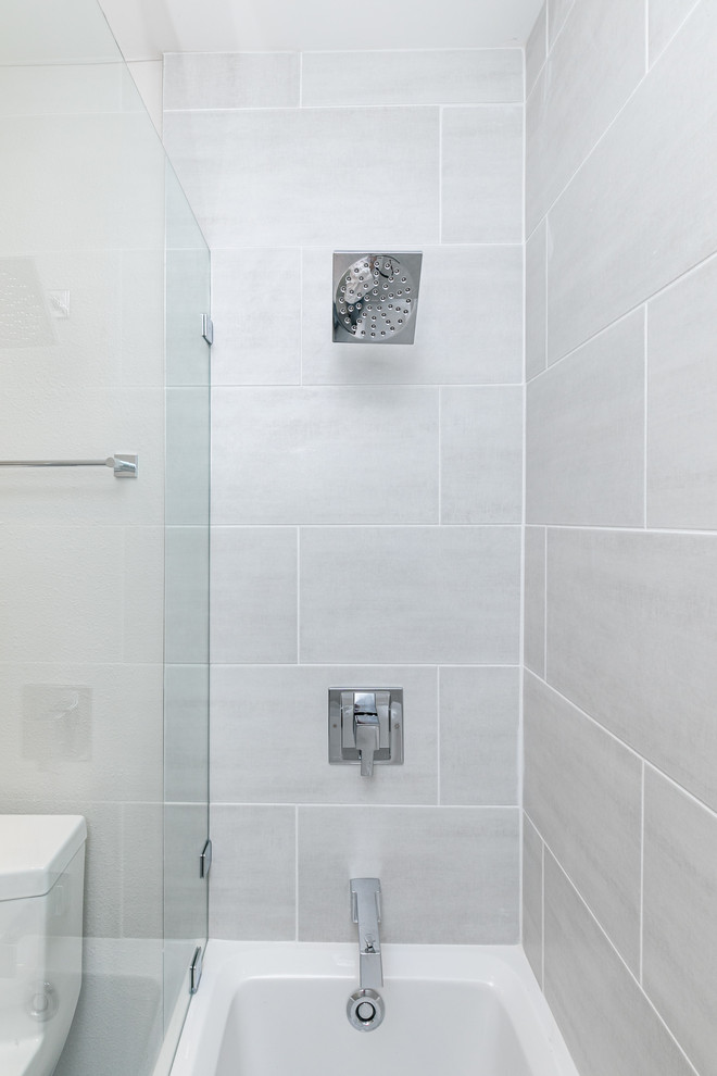 Maritimes Badezimmer mit Duschbadewanne, grauen Fliesen, Keramikfliesen und Falttür-Duschabtrennung in San Diego