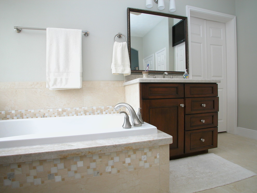Large transitional master beige tile and porcelain tile porcelain tile drop-in bathtub photo in Houston with recessed-panel cabinets, dark wood cabinets, quartzite countertops and gray walls