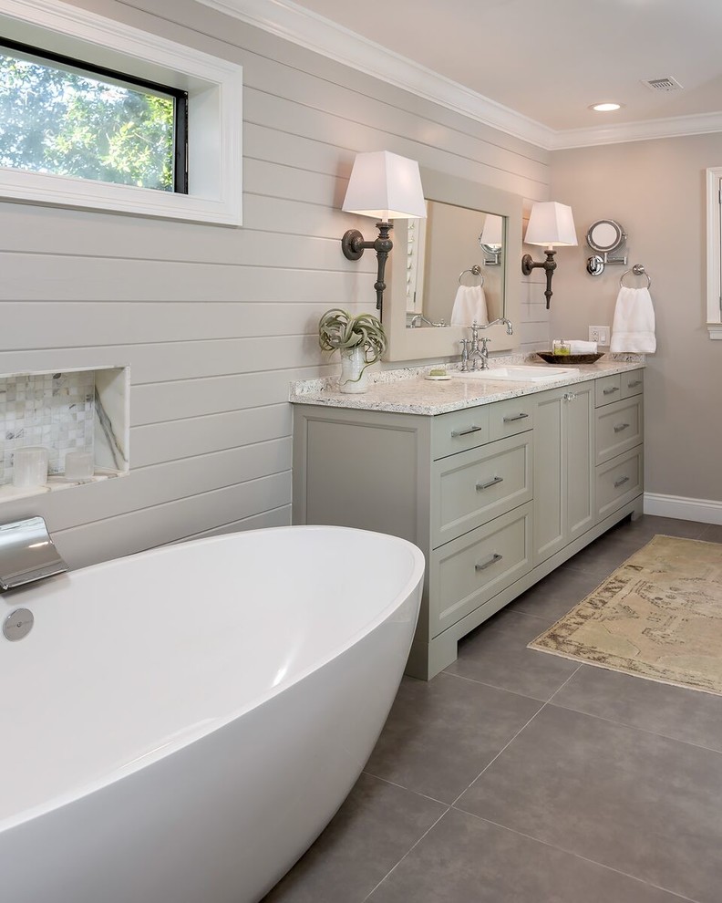 Example of a mid-sized beach style master porcelain tile and gray floor bathroom design in Other with recessed-panel cabinets, gray cabinets, beige walls, a drop-in sink, granite countertops and a hinged shower door
