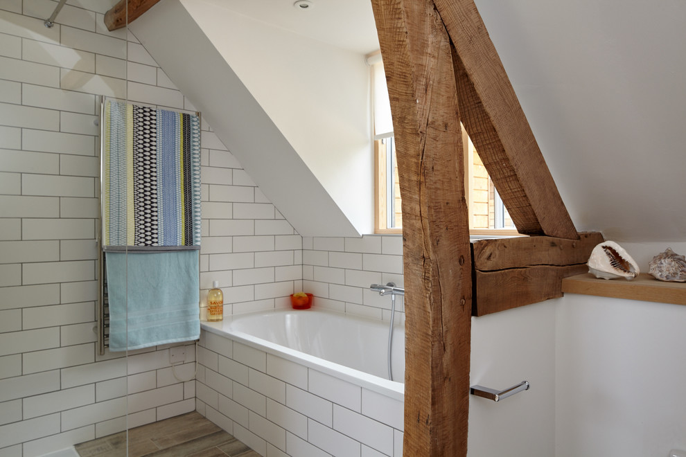 На фото: ванная комната в морском стиле с ванной в нише, белой плиткой и белыми стенами