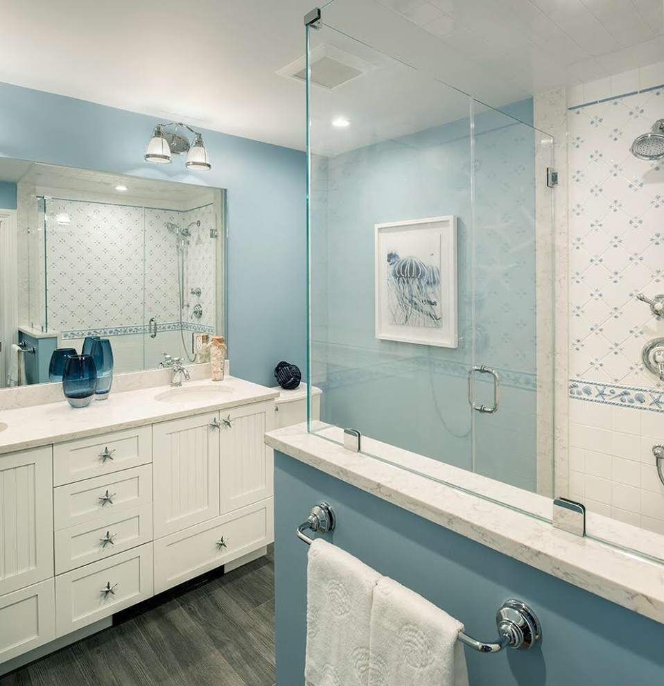 Imagen de cuarto de baño principal costero de tamaño medio con puertas de armario blancas y ducha con puerta con bisagras
