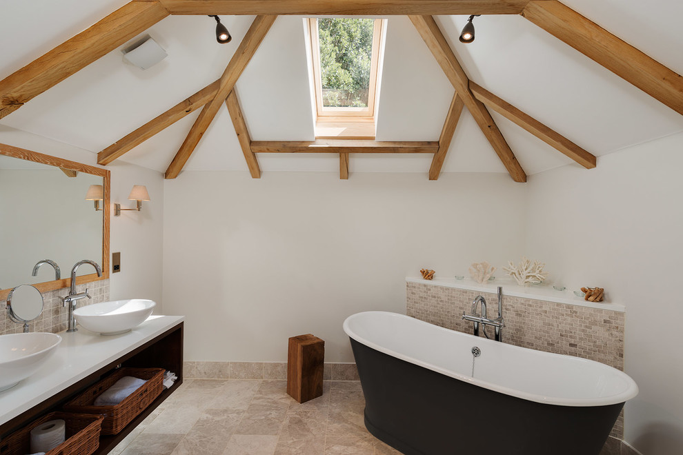 Coastal ensuite bathroom in Devon with a vessel sink, open cabinets, a freestanding bath, mosaic tiles, beige walls and beige tiles.