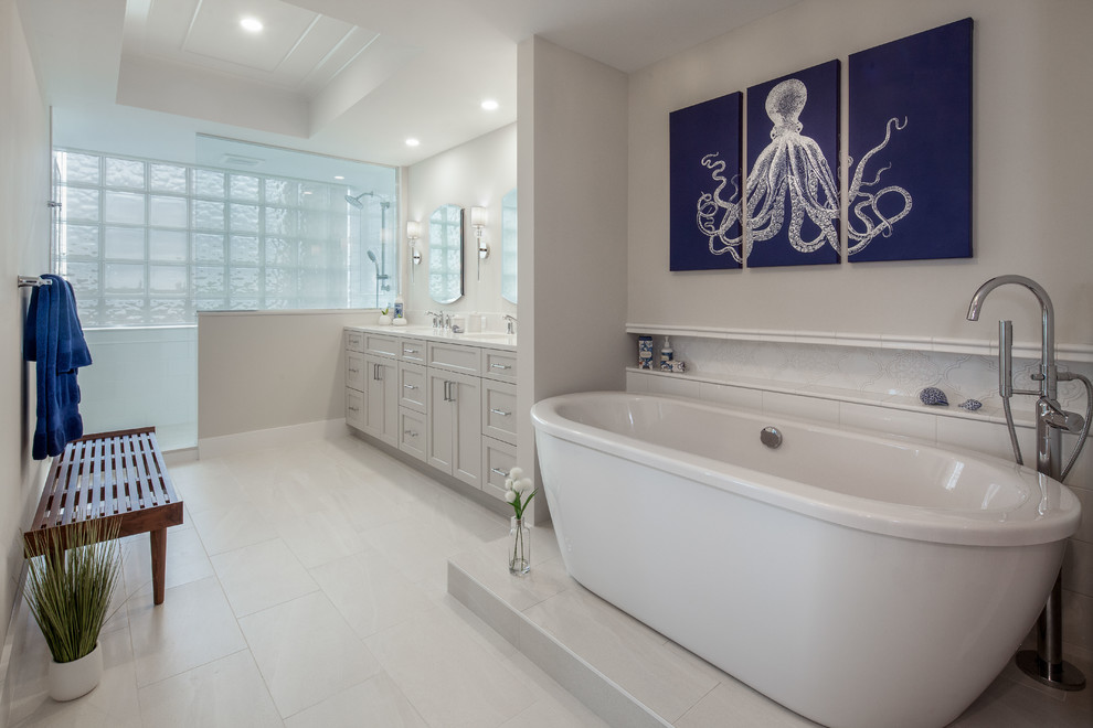 Стильный дизайн: маленькая главная ванная комната в морском стиле с фасадами с утопленной филенкой, серыми фасадами, отдельно стоящей ванной, открытым душем, раздельным унитазом, белой плиткой, керамогранитной плиткой, синими стенами, полом из керамогранита, врезной раковиной, столешницей из кварцита, бежевым полом, открытым душем и белой столешницей для на участке и в саду - последний тренд