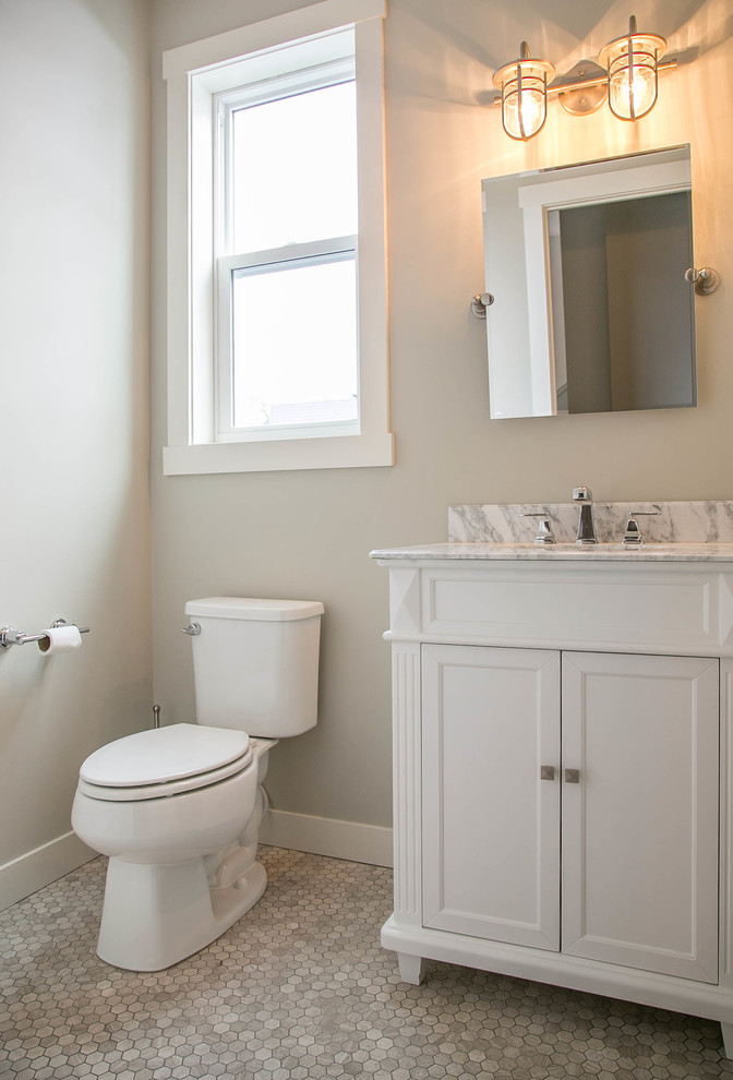 Foto di una stanza da bagno classica con ante in stile shaker, ante bianche, WC monopezzo, pareti grigie, pavimento con piastrelle in ceramica, lavabo sottopiano e top in marmo