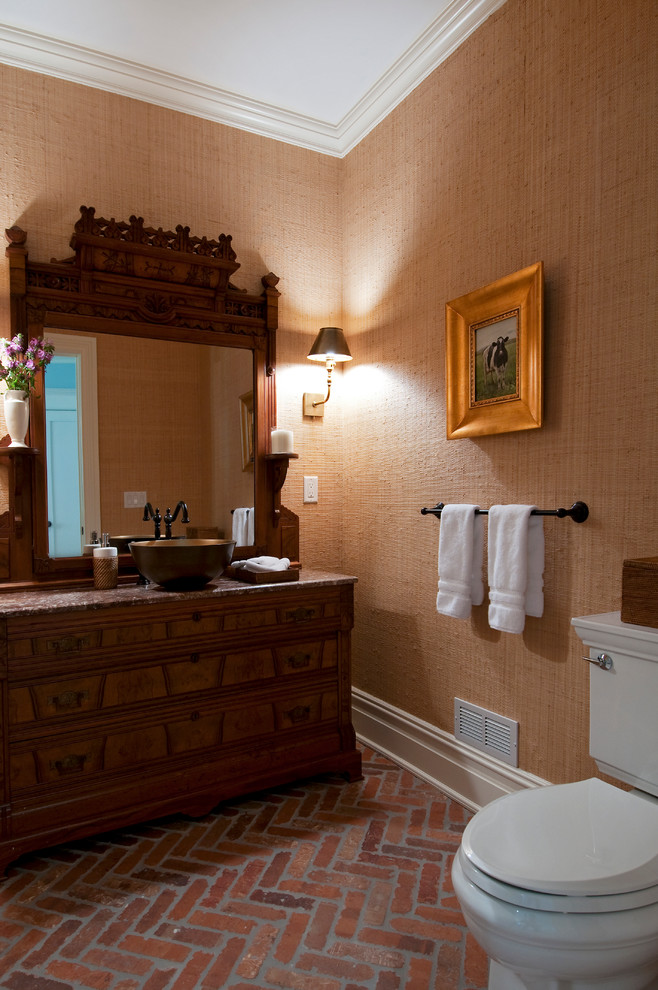 Foto på ett vintage brun badrum, med skåp i shakerstil, beige skåp, en toalettstol med separat cisternkåpa, orange väggar, tegelgolv, ett fristående handfat, granitbänkskiva och brunt golv