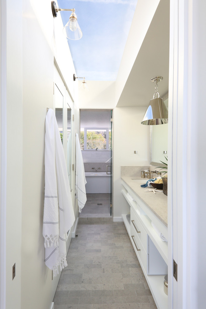 Coastal bathroom in Santa Barbara with flat-panel cabinets, white cabinets, an alcove shower, white walls and a submerged sink.