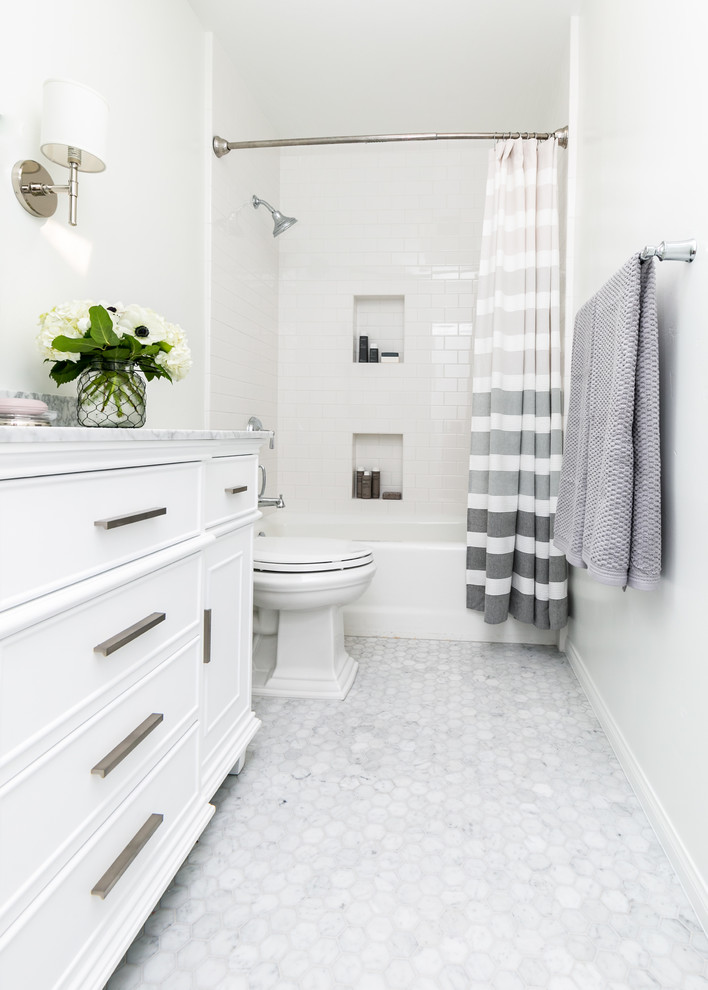 Идея дизайна: ванная комната в стиле неоклассика (современная классика) с белыми фасадами, ванной в нише, душем над ванной, раздельным унитазом, белой плиткой, белыми стенами, белым полом, шторкой для ванной, серой столешницей и фасадами с утопленной филенкой
