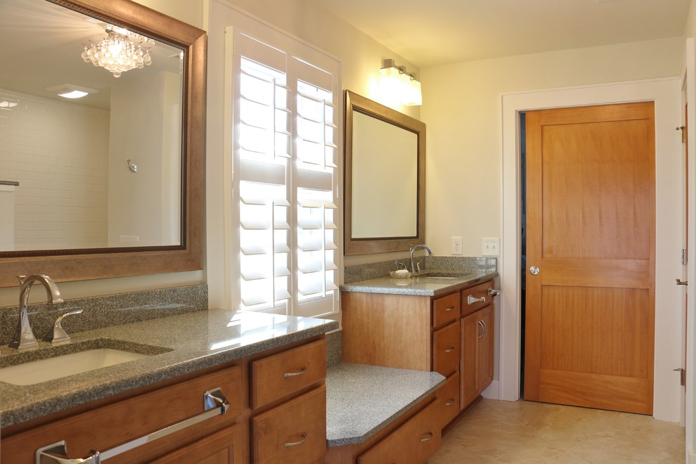 Cette photo montre une salle de bain principale bord de mer en bois brun avec un placard à porte shaker, un carrelage beige, des carreaux de porcelaine, un mur gris, un sol en carrelage de porcelaine, un lavabo encastré et un plan de toilette en granite.