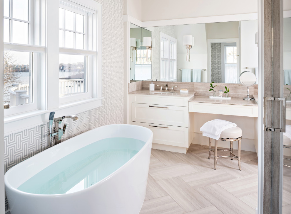 Bild på ett maritimt beige beige badrum, med skåp i shakerstil, vita skåp, ett fristående badkar, beige väggar, ett undermonterad handfat och beiget golv