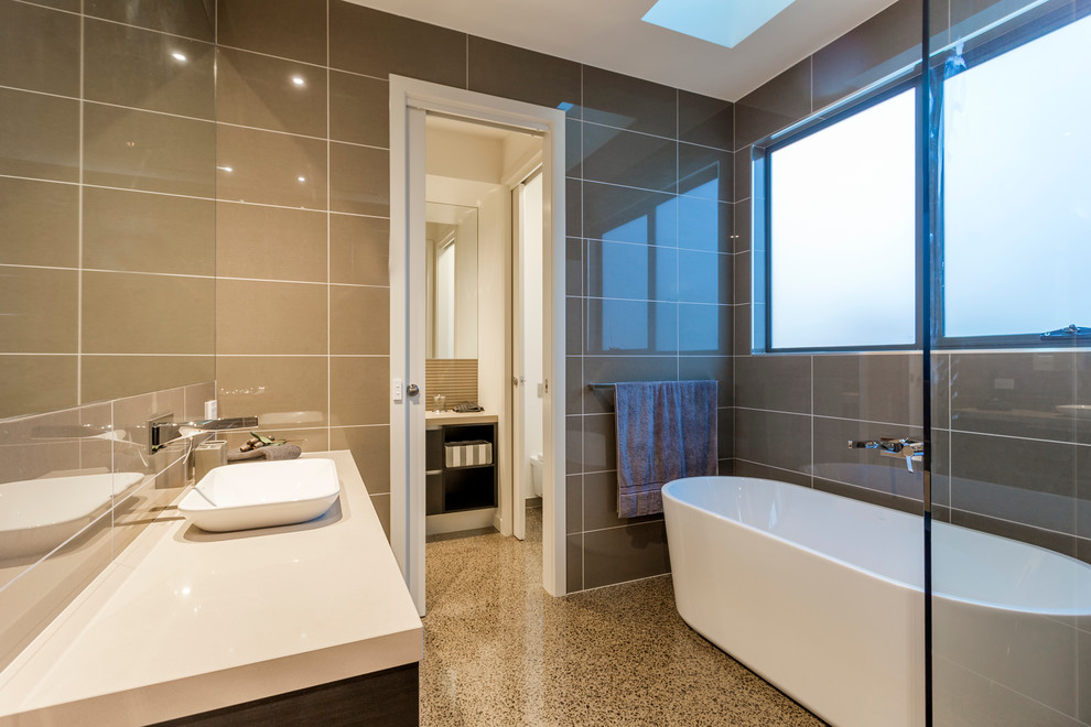 ジーロングにあるコンテンポラリースタイルのおしゃれな浴室 (オーバーカウンターシンク、置き型浴槽、オープン型シャワー、茶色いタイル、コンクリートの床) の写真