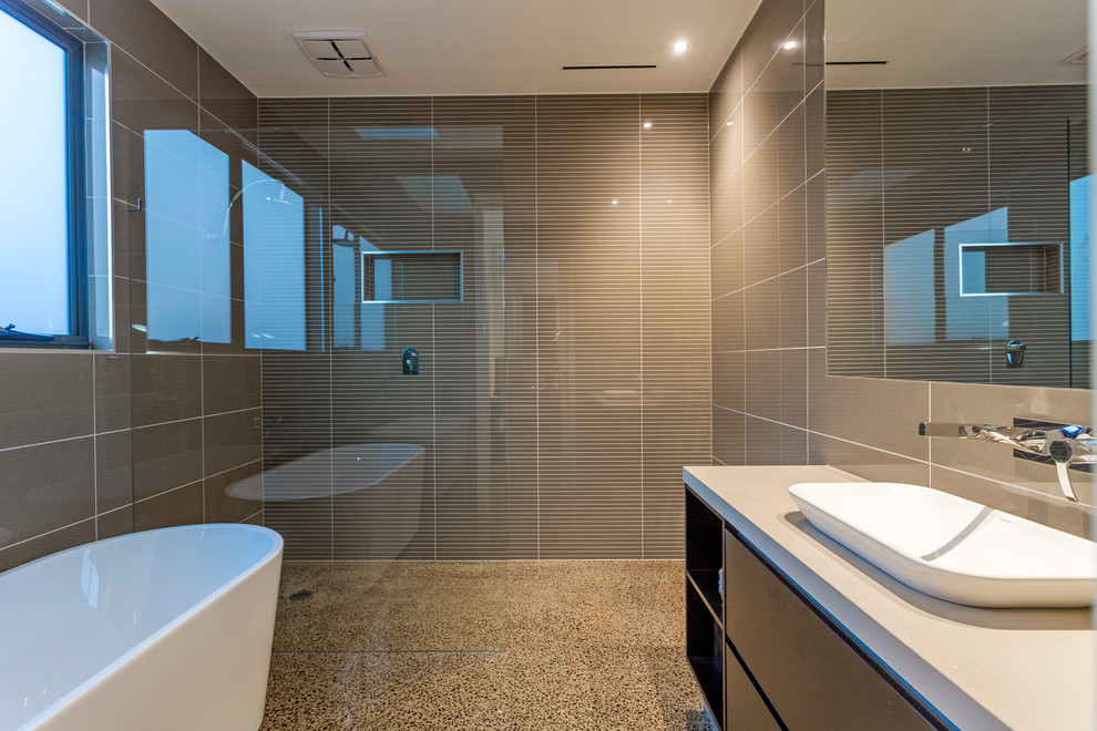 Aménagement d'une salle de bain contemporaine avec un lavabo posé, une baignoire indépendante, une douche ouverte, un carrelage marron et sol en béton ciré.