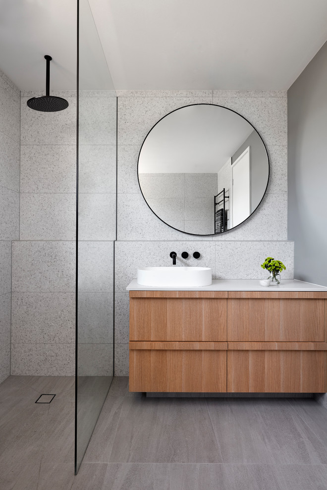 Example of a mid-sized beach style master gray tile and stone tile gray floor bathroom design in Melbourne with recessed-panel cabinets, light wood cabinets, a vessel sink, concrete countertops, a hinged shower door and white countertops