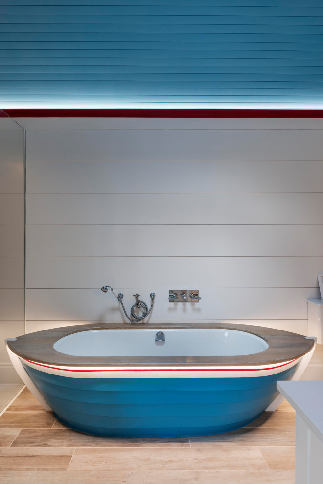 Photo of a medium sized coastal family bathroom in Devon with shaker cabinets, white cabinets, a freestanding bath, a walk-in shower, white tiles, white walls, medium hardwood flooring, a wall-mounted sink, solid surface worktops, brown floors, an open shower, white worktops, a single sink, a freestanding vanity unit, a timber clad ceiling and panelled walls.